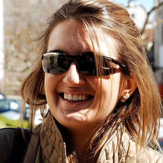 woman with sunglasses smiling outside